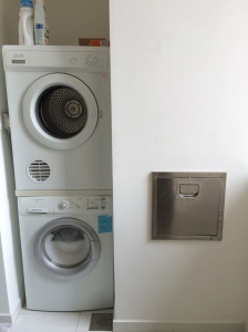 Washer, dryer, and trash chute in wet kitchen